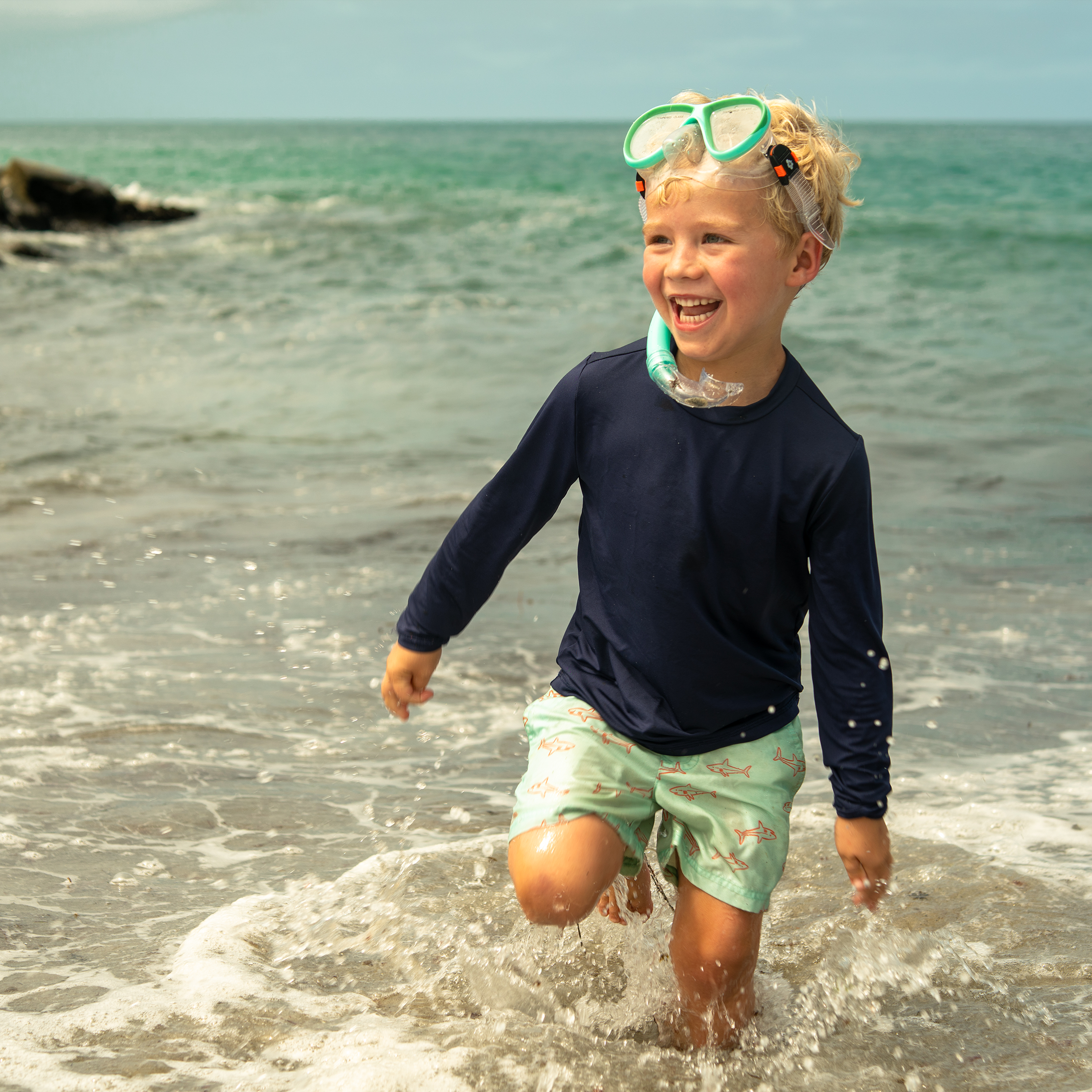 Little boy in the ocean with mask and snorkel gear