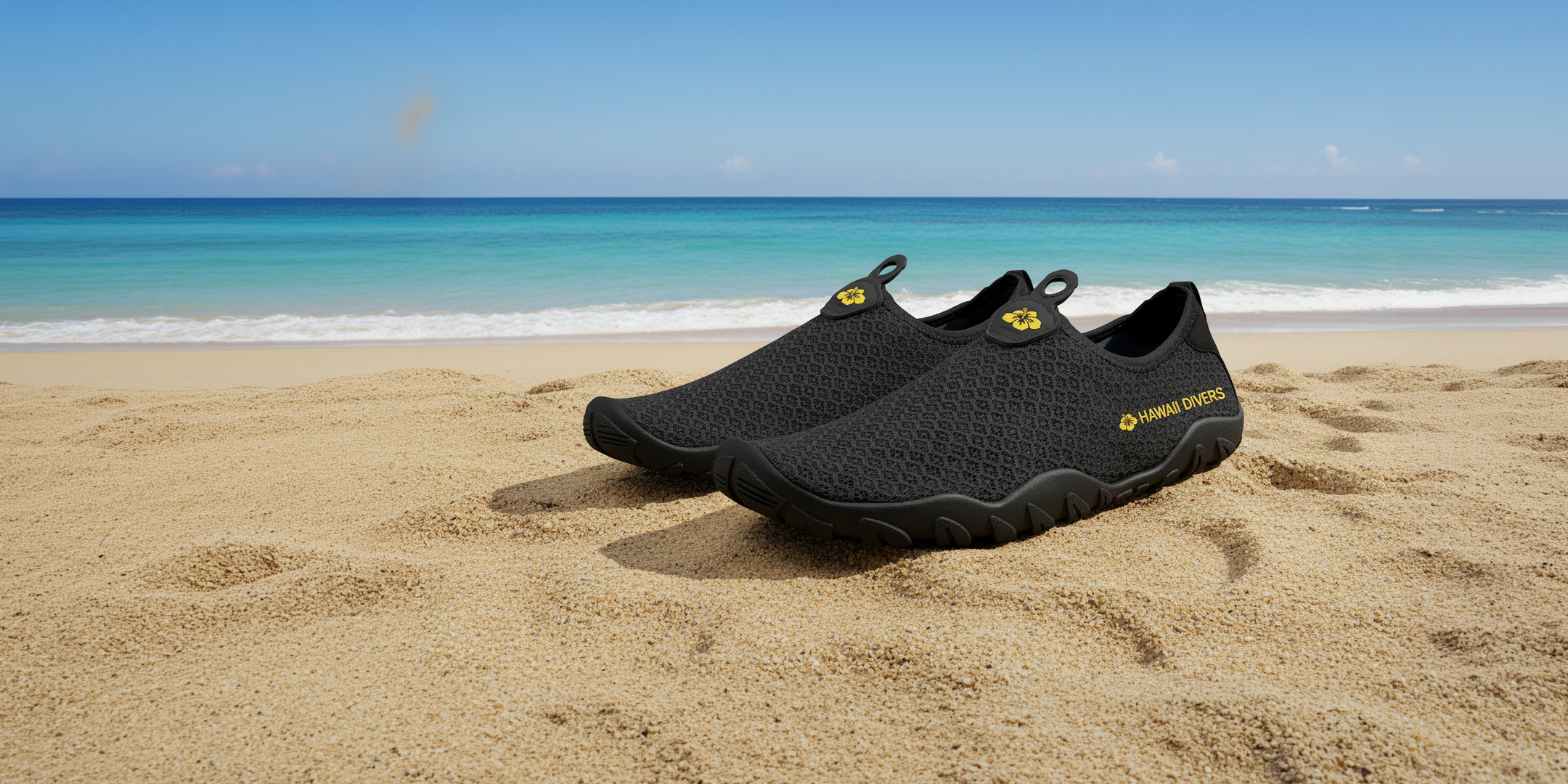 Black water shoes on a sandy beach with ocean in the background